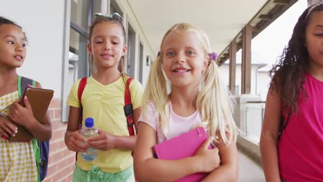 Video-Von-Glücklichen,-Vielfältigen-Mädchen,-Die-Durch-Den-Schulkorridor-Gehen-Und-Reden