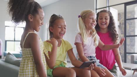Video-Von-Verschiedenen-Mädchen,-Die-Mit-Ihrem-Smartphone-Im-Gemeinschaftsraum-Der-Schule-Sitzen,-Reden-Und-Lachen