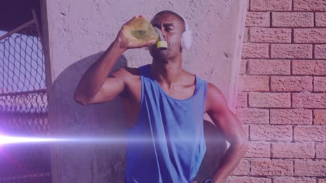 Animation-of-glowing-lights-over-an-exercising-african-american-man-drinking-water