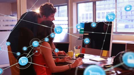 Animation-of-network-of-connections-with-icons-over-caucasian-man-and-woman-using-computer