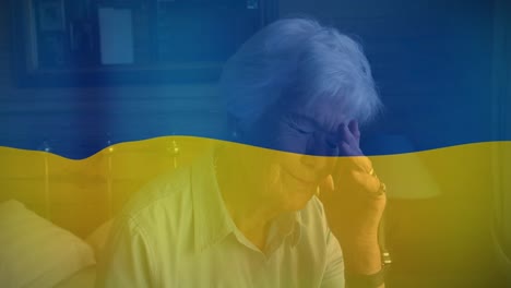 Animation-of-flag-of-ukraine-over-senior-caucasian-woman-crying