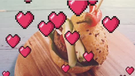 Animation-of-hearts-floating-over-burger-on-wooden-board