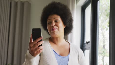 Video-of-happy-plus-size-african-american-woman-using-smartphone