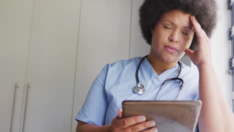 Video-Einer-Müden,-übergroßen-Afroamerikanischen-Ärztin,-Die-Ein-Tablet-Benutzt