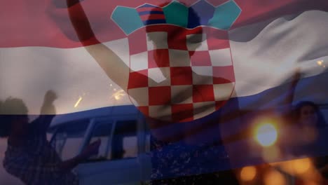 Animation-of-waving-croatia-flag-over-group-of-friend-on-the-beach