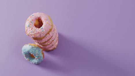 Video-Von-Donuts-Mit-Zuckerguss-Auf-Violettem-Hintergrund
