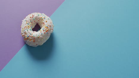 Video-Von-Donuts-Mit-Zuckerguss-Auf-Blauem-Und-Violettem-Hintergrund