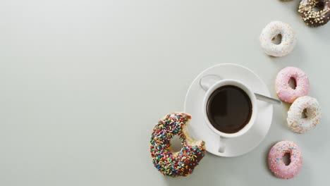 Video-of-donuts-with-icing-and-cup-of-coffee-on-white-background