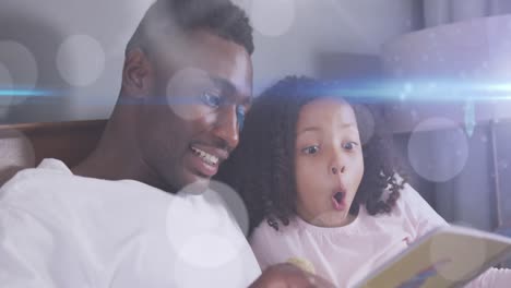 Animation-of-light-spots-over-happy-african-american-father-reading-book-with-daughter