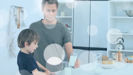 Animation-of-white-spots-over-happy-caucasian-father-drinking-milk-with-son