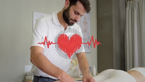 Animation-of-heart-over-caucasian-male-massage-therapist-with-female-patient