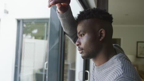 Video-Eines-Traurigen-Afroamerikanischen-Mannes,-Der-Aus-Dem-Fenster-Schaut