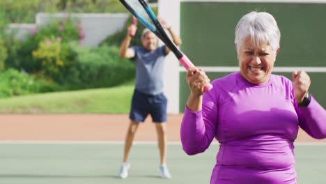 Video-Einer-Glücklichen-Gemischtrassigen-Seniorin,-Die-Beim-Tennistraining-Vor-Freude-Springt