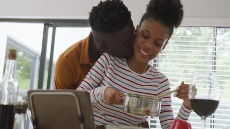 Video-Eines-Glücklichen-Afroamerikanischen-Paares,-Das-Sich-Beim-Gemeinsamen-Kochen-In-Der-Küche-Umarmt