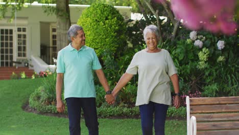Video-Eines-Glücklichen-Gemischtrassigen-älteren-Paares,-Das-Sich-Im-Garten-An-Den-Händen-Hält