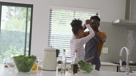 Video-Eines-Glücklichen-Afroamerikanischen-Paares,-Das-Beim-Gemeinsamen-Kochen-In-Der-Küche-Tanzt
