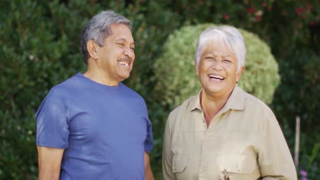 Video-Eines-Glücklichen-Gemischtrassigen-älteren-Paares,-Das-Im-Garten-Lacht-Und-Redet
