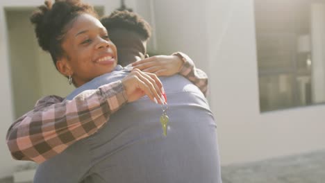Video-Eines-Glücklichen-Afroamerikanischen-Paares,-Das-Sich-Umarmt-Und-Die-Schlüssel-Zum-Neuen-Haus-Zeigt