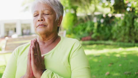 Vídeo-De-Una-Anciana-Birracial-Relajada-Practicando-Yoga-En-El-Jardín