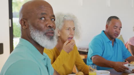 Portrait-of-happy-senior-diverse-people-having-breakfast-at-retirement-home