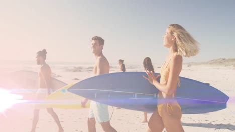 Animation-of-light-over-happy-diverse-friends-walking-on-beach-with-surfboards
