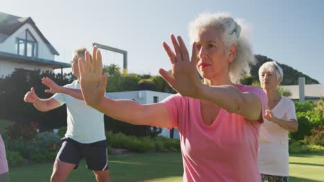 Senior-diverse-people-exercising-in-garden-on-sunny-day-at-retirement-home