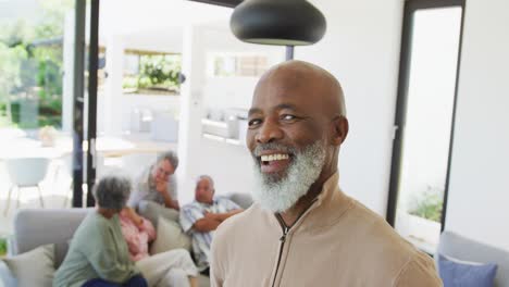Portrait-of-happy-senior-african-american-man-with-other-seniors-at-retirement-home