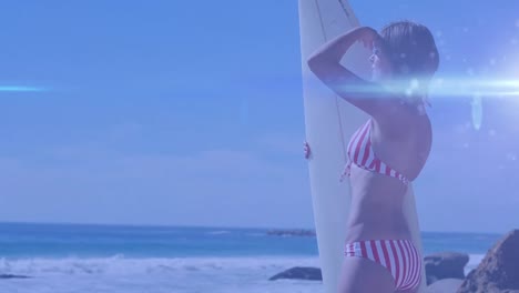 Animation-of-light-over-happy-caucasian-woman-holding-surfboard-and-looking-into-distance