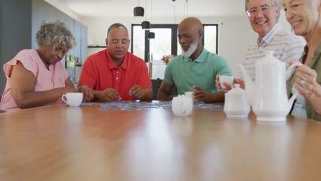 Glückliche-ältere,-Vielfältige-Menschen,-Die-Am-Tisch-Im-Altersheim-Puzzle-Spielen