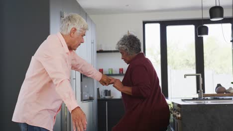 Glückliches-älteres,-Vielfältiges-Paar,-Das-In-Der-Küche-Im-Altersheim-Tanzt