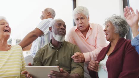 Happy-senior-diverse-people-talking-and-using-laptop-at-retirement-home