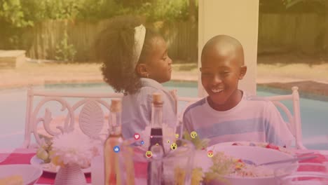 Animation-Von-Fallenden-Verschiedenen-Emojis-über-Zwei-Glückliche-Afroamerikanische-Kinder