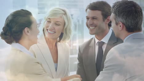 Animation-of-happy-caucasian-businesspeople-shaking-hands-and-talking-over-cityscape