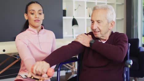 Video-Einer-Glücklichen-Gemischtrassigen-Physiotherapeutin,-Die-Mit-Einem-Kaukasischen-älteren-Mann-Trainiert