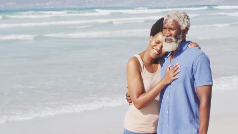 Glückliches-Afroamerikanisches-Paar,-Das-Sich-Am-Sonnigen-Strand-Umarmt-Und-Wegschaut