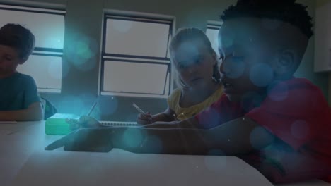 Blue-spots-of-light-against-diverse-boy-and-girl-studying-together-in-the-class-at-school