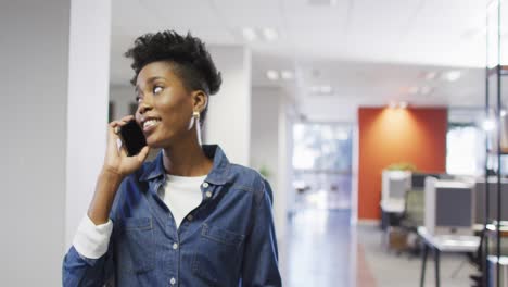 Video-Einer-Afroamerikanischen-Geschäftsfrau,-Die-Im-Büro-Läuft-Und-Ihr-Smartphone-Benutzt