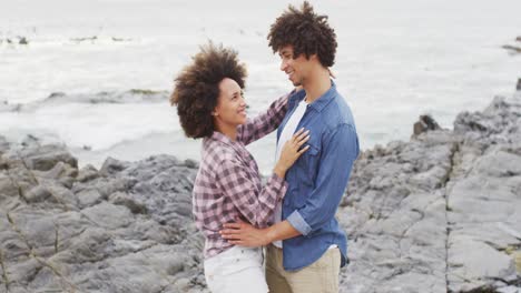 Close-up-of-african-american-couple-dancing-together-on-the-rocks-near-the-sea