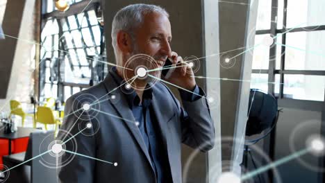 Animation-of-network-of-connections-over-caucasian-businessman-talking-on-smartphone