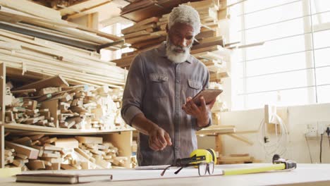 African-american-male-carpenter-using-digital-tablet-in-a-carpentry-shop