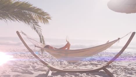 Animation-of-light-spots-over-caucasian-woman-lying-in-hammock-at-beach