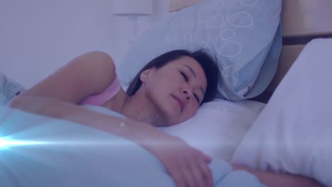 Animation-of-light-spots-over-asian-woman-lying-in-bed