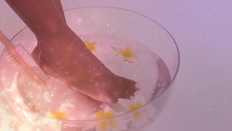 Animation-of-light-spots-over-african-american-woman-washing-feet