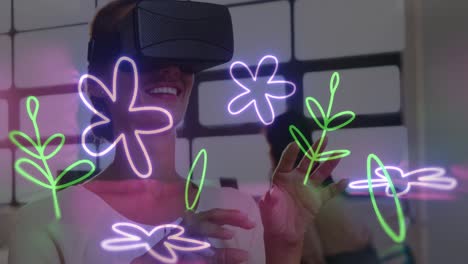 Animation-of-flower-neon-shapes-over-caucasian-woman-using-vr-headset