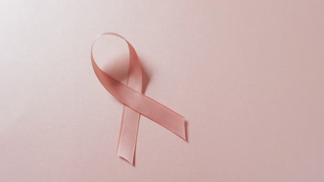 Video-of-pink-breast-cancer-ribbon-on-pale-pink-background