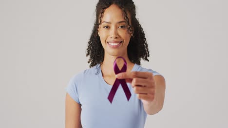 Video-of-smiling-biracial-woman-holding-black-melanoma-cancer-ribbon