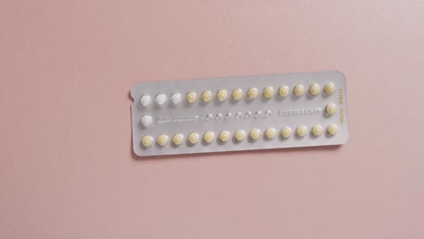 Video-of-close-up-of-yellow-tablets-on-pink-background