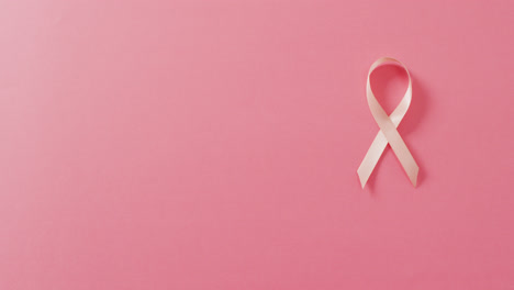 Video-of-pale-pink-breast-cancer-ribbon-on-pink-background