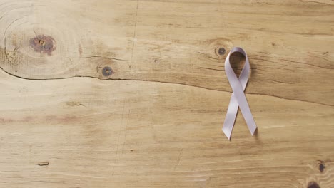 Video-of-white-lung-cancer-ribbon-on-wooden-background