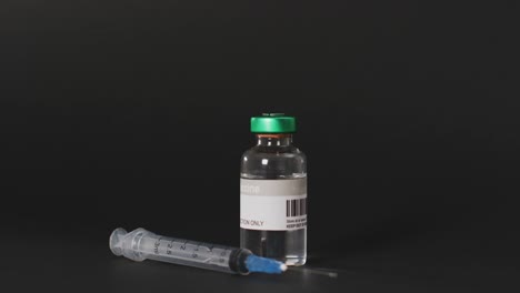Video-of-close-up-of-vaccine-vial-on-black-background